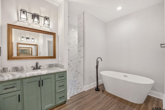 bathroom featuring hardwood / wood-style floors, vanity, and plus walk in shower