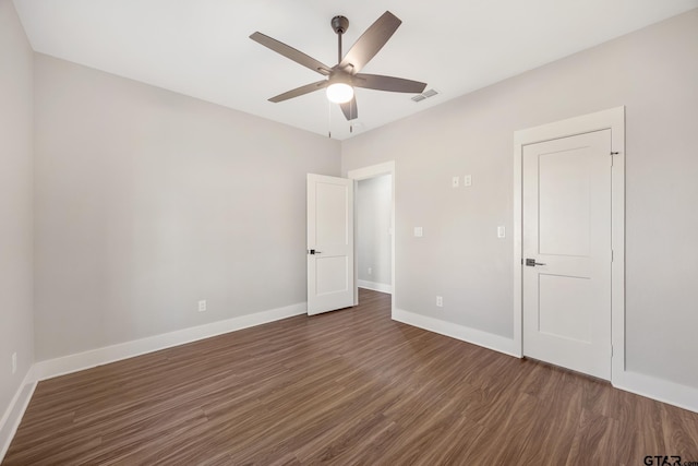 unfurnished bedroom featuring ceiling fan and dark wood-type flooring