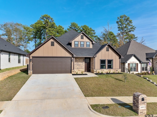 9161 Cave Branch Cv, Tyler, TX 75703 - view of front of house with board and batten siding, roof with shingles, driveway, an attached garage, and a front lawn