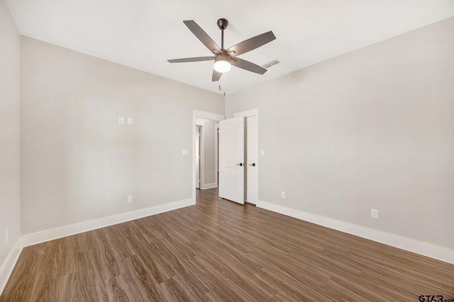 unfurnished room with dark hardwood / wood-style flooring and ceiling fan