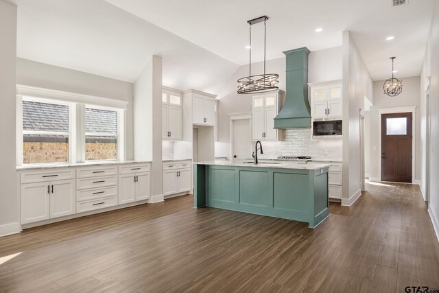 kitchen with built in microwave, dark hardwood / wood-style floors, premium range hood, a chandelier, and decorative light fixtures