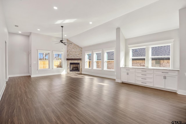 unfurnished living room featuring a fireplace, dark hardwood / wood-style flooring, high vaulted ceiling, and ceiling fan