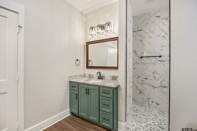 bathroom featuring hardwood / wood-style flooring, vanity, and a tile shower