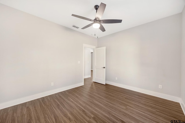 empty room featuring ceiling fan and dark wood-type flooring