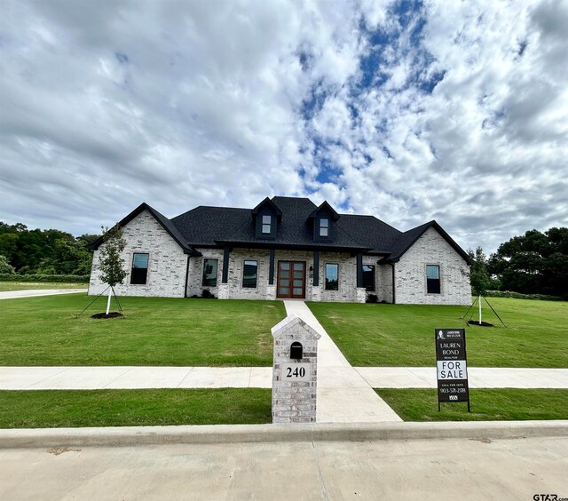 french country home with a front lawn