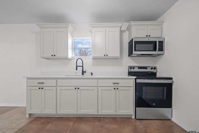 kitchen featuring sink, white cabinets, stainless steel appliances, and light tile patterned flooring