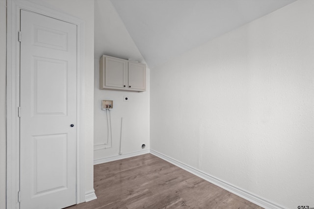 washroom with light wood-type flooring, hookup for a washing machine, electric dryer hookup, and cabinets