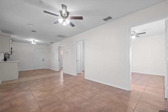 tiled spare room with ceiling fan and sink