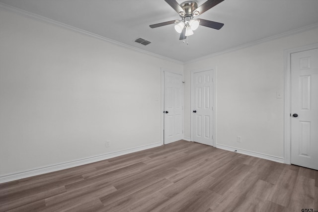 empty room featuring ceiling fan, crown molding, and light hardwood / wood-style floors