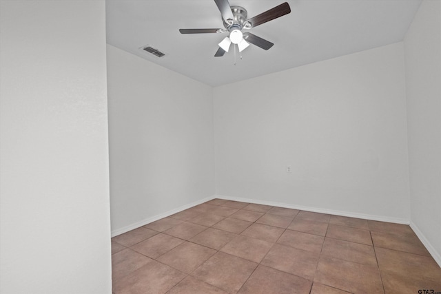 tiled spare room with ceiling fan