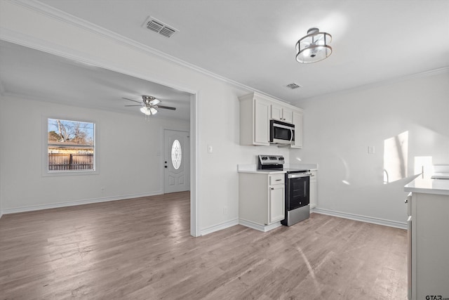 kitchen featuring ceiling fan, stainless steel appliances, ornamental molding, and white cabinets