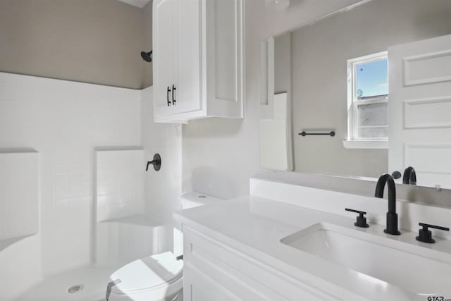 bathroom with walk in shower, vanity, and toilet