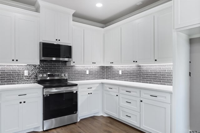 kitchen with tasteful backsplash, appliances with stainless steel finishes, dark hardwood / wood-style floors, and white cabinets