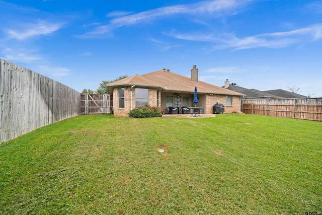 rear view of house with a patio, brick siding, a lawn, and a fenced backyard