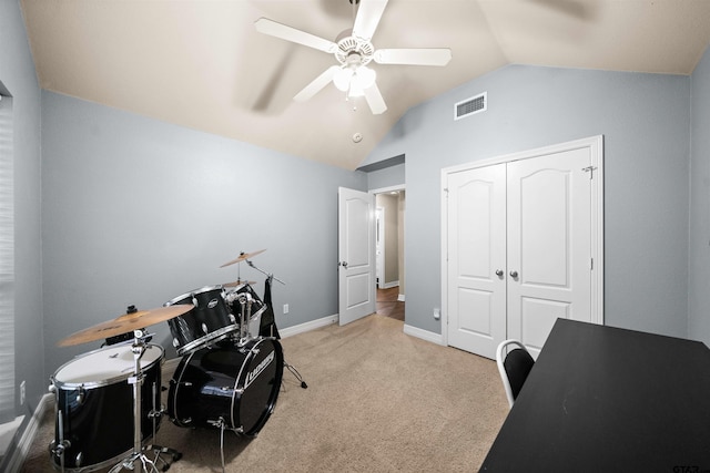 office space with carpet flooring, a ceiling fan, visible vents, vaulted ceiling, and baseboards