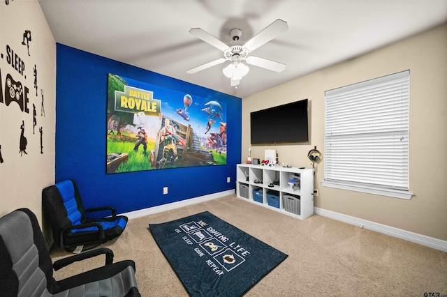 carpeted cinema with ceiling fan and baseboards