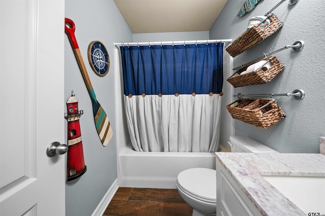 bathroom featuring a textured wall, toilet, shower / tub combo with curtain, wood finished floors, and vanity