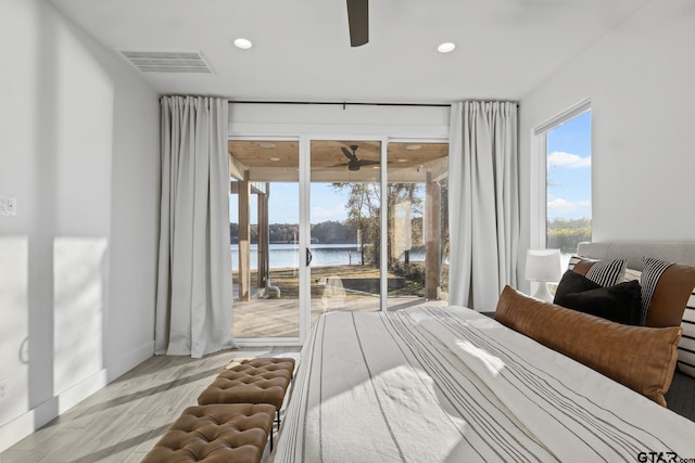 bedroom featuring access to outside, a water view, and light wood-type flooring