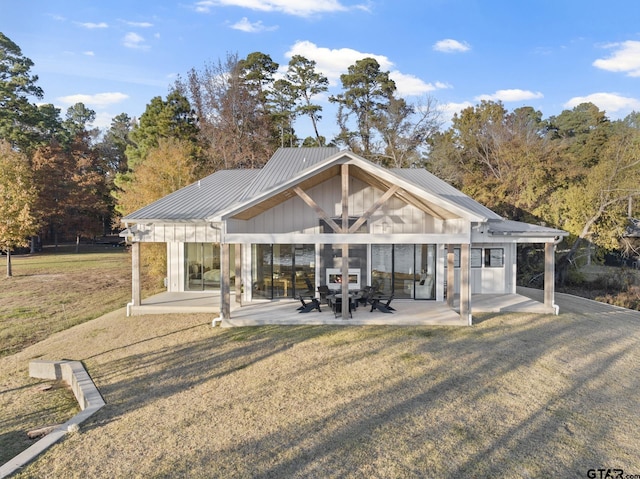 back of house featuring a lawn and a patio area