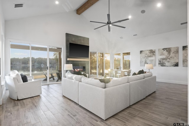 living room featuring ceiling fan, beam ceiling, a fireplace, and high vaulted ceiling