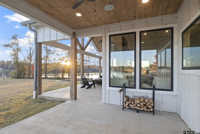 view of patio with ceiling fan and a water view