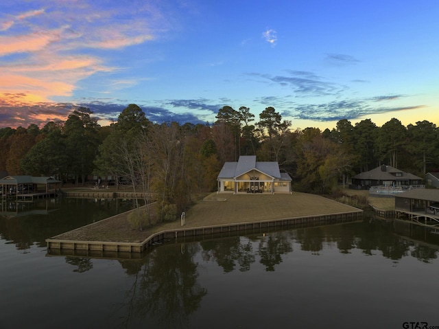 aerial view at dusk featuring a water view