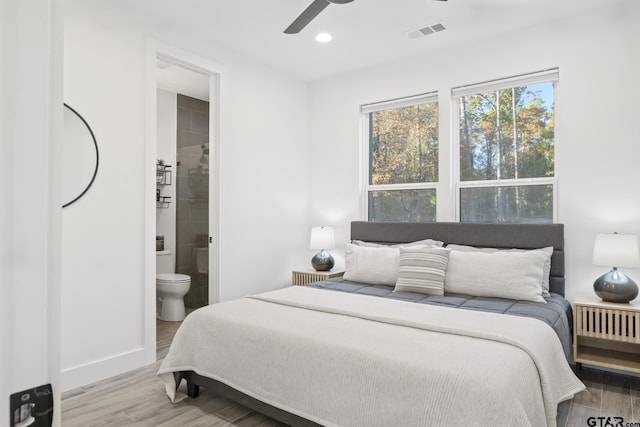 bedroom with light hardwood / wood-style flooring, ensuite bath, and ceiling fan