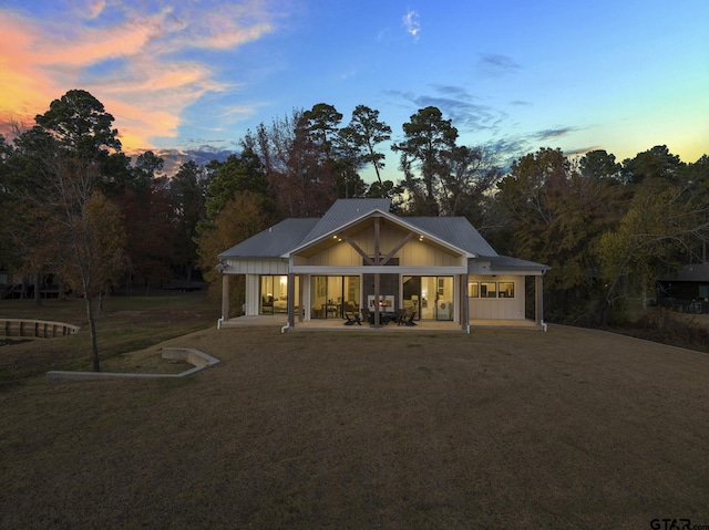 view of front of house with a patio area and a yard