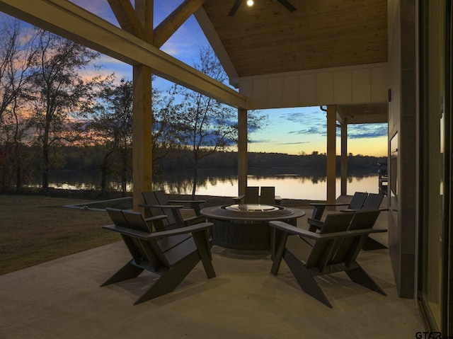 patio terrace at dusk with ceiling fan and a water view