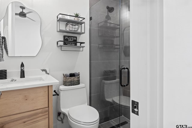 bathroom with vanity, toilet, and a shower with shower door