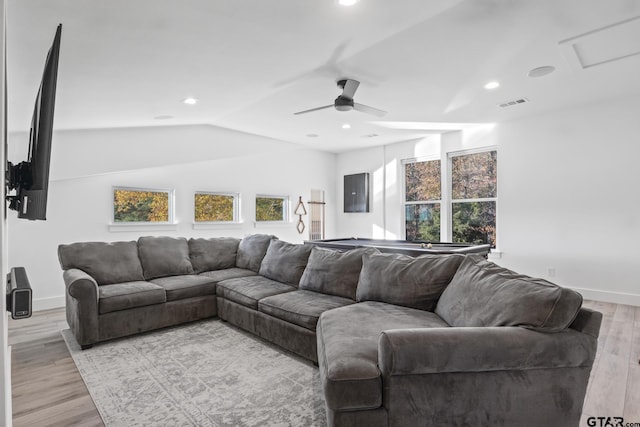 living room with ceiling fan, light hardwood / wood-style floors, and vaulted ceiling