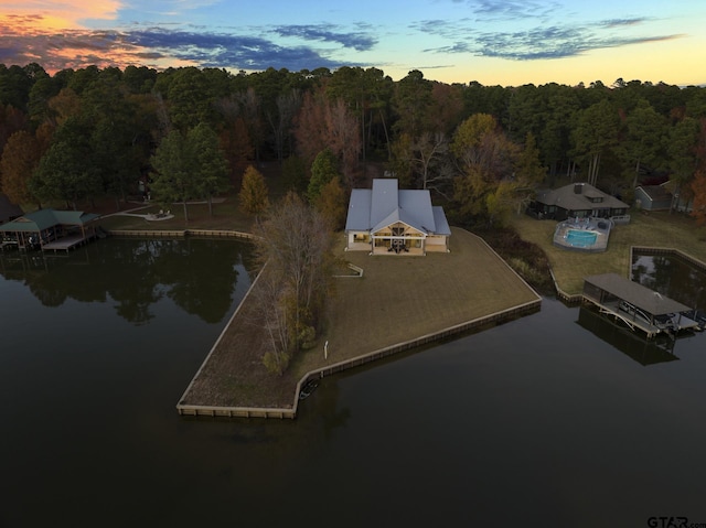 aerial view at dusk featuring a water view