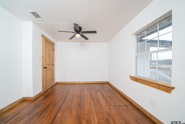 empty room featuring ceiling fan, dark hardwood / wood-style flooring, and a textured ceiling