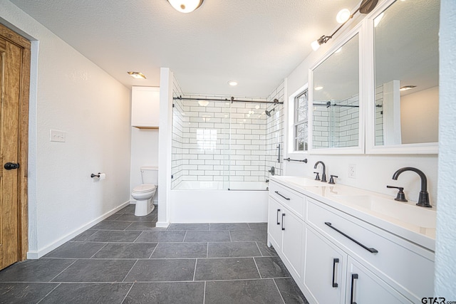 full bathroom featuring vanity, tiled shower / bath combo, a textured ceiling, and toilet