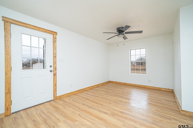 foyer entrance with ceiling fan, light hardwood / wood-style flooring, and a textured ceiling