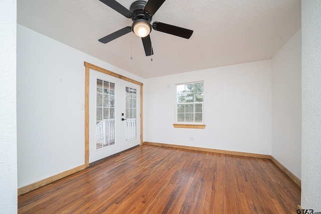 empty room featuring french doors, a textured ceiling, and hardwood / wood-style flooring