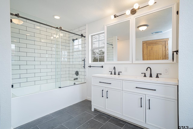 bathroom featuring enclosed tub / shower combo, vanity, and a textured ceiling