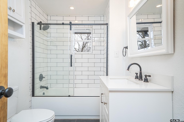 full bathroom featuring vanity, shower / bath combination with glass door, and toilet