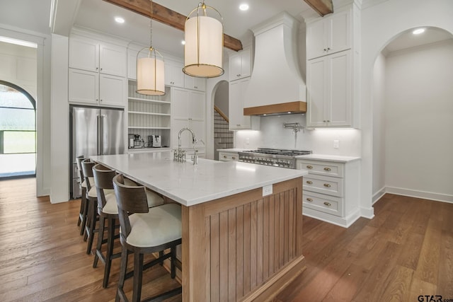 3116 Forest Ridge Cv, Tyler, TX 75703 - kitchen featuring custom exhaust hood, stainless steel refrigerator, arched walkways, open shelves, and beamed ceiling