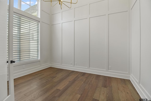 3116 Forest Ridge Cv, Tyler, TX 75703 - unfurnished room with a decorative wall, a chandelier, and dark wood-style flooring