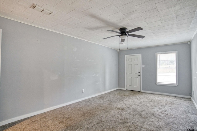 empty room featuring carpet, ceiling fan, and crown molding