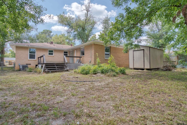 rear view of house featuring cooling unit, a yard, a shed, and a deck