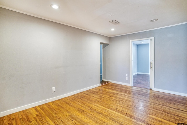 empty room with light wood-type flooring and crown molding