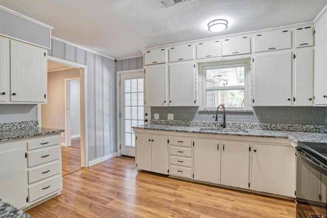 kitchen featuring backsplash, white cabinets, sink, and light wood-type flooring