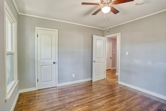 spare room featuring dark hardwood / wood-style flooring, ceiling fan, and crown molding