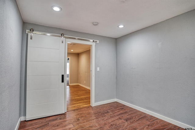 spare room featuring a barn door and wood-type flooring