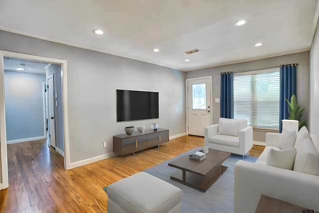 living room with hardwood / wood-style flooring and crown molding