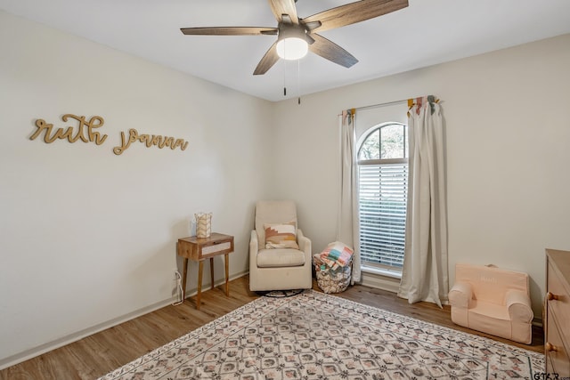 living area featuring ceiling fan and wood-type flooring