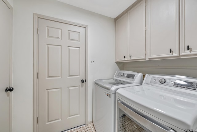 washroom featuring washer and dryer and cabinets