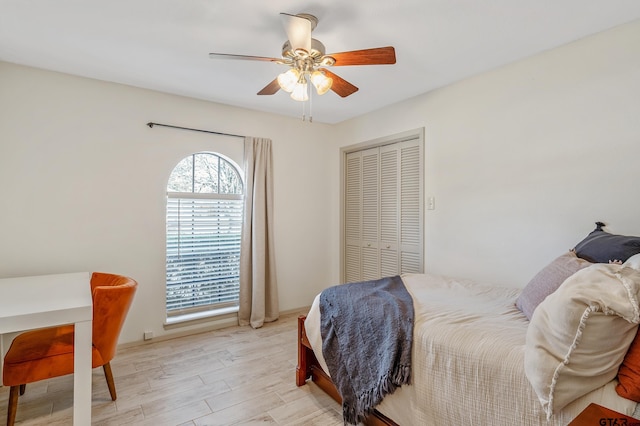 bedroom with ceiling fan, light hardwood / wood-style floors, and a closet